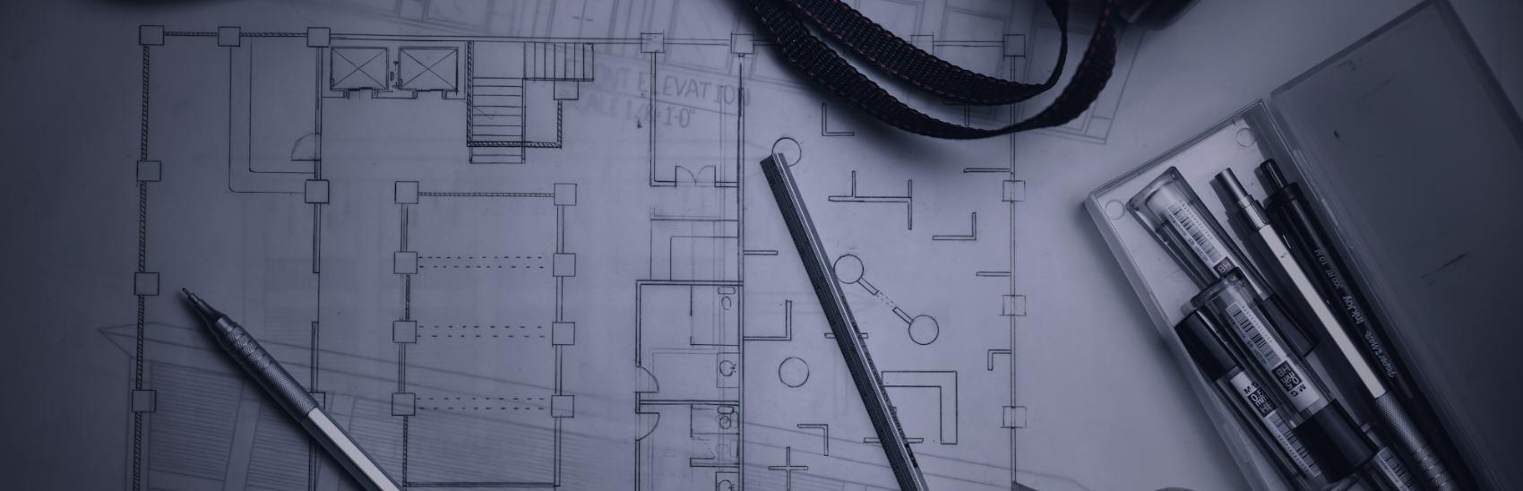 Architectural floor plans with a scale rule, pens and a drawing tube